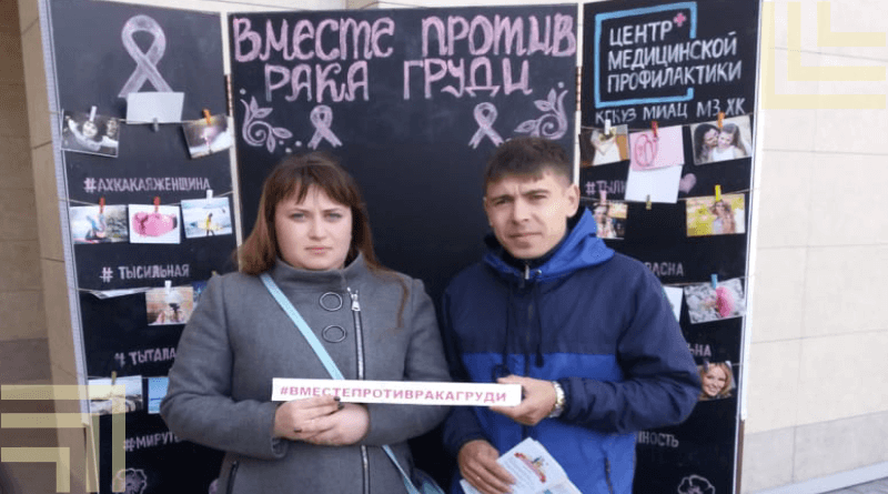 Девушка и парень возле мелованной доски акция "Вместе против рака груди"